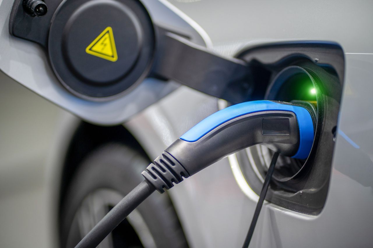A close up of an electric car being charged.