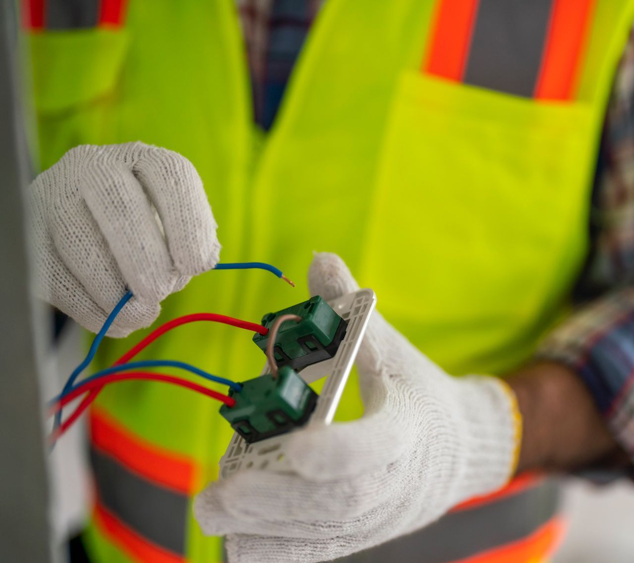 An electrician is working on a light switch.