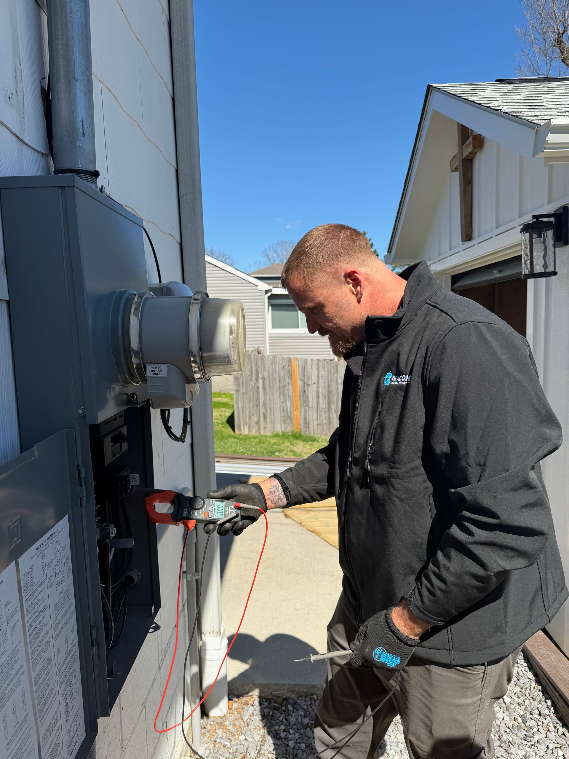 Electrician using a power tool to work on electrical panel.