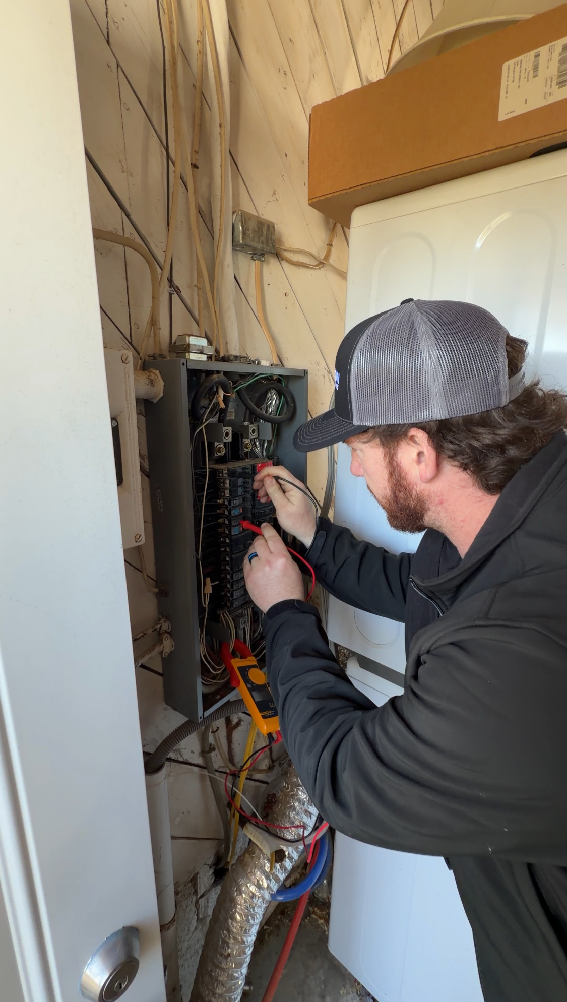Inside a white electrical box: various wires, circuits, and terminals connected to electronic components.