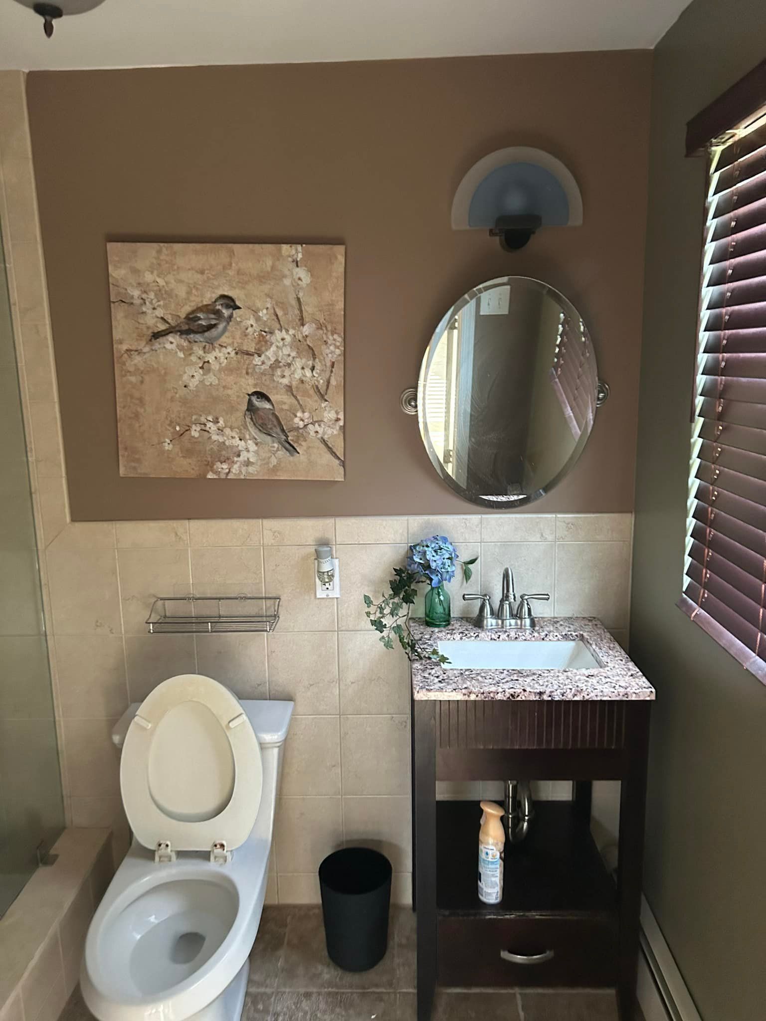 A bathroom with a toilet a sink and a mirror