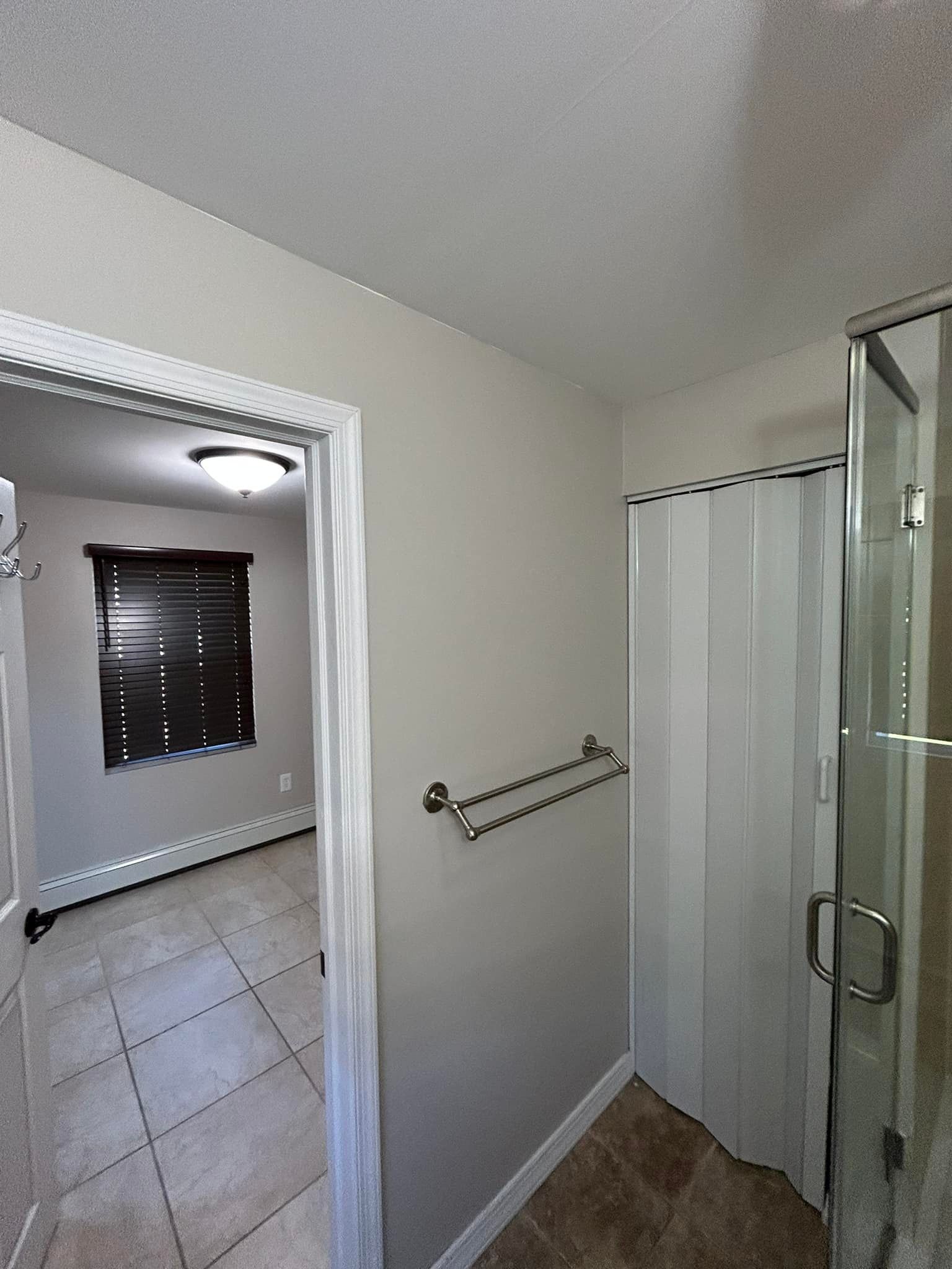 A bathroom with a walk in shower and a window.