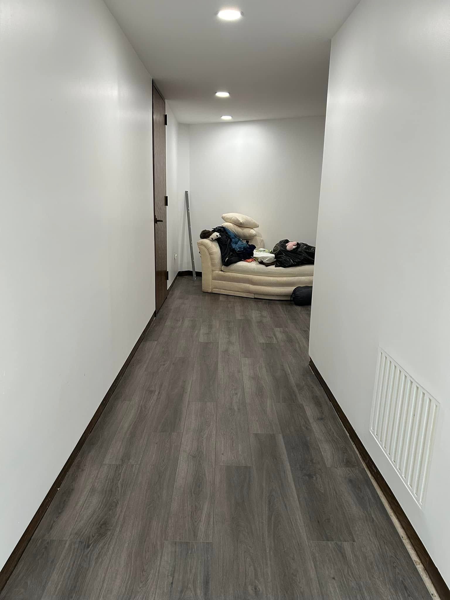 A long hallway with a couch in the middle of it