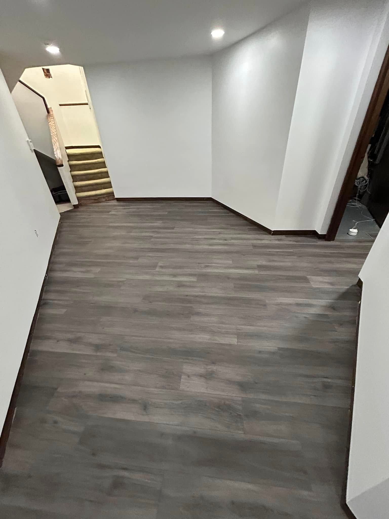 A hallway with a wooden floor and white walls.