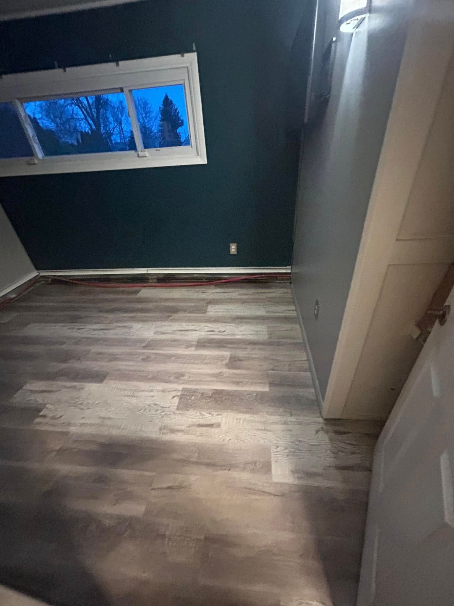 A room with a wooden floor and a window.