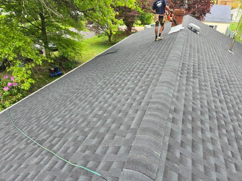A man is working on the roof of a house.