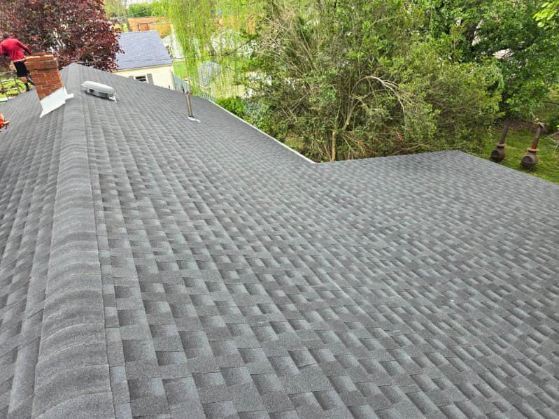 A man is working on the roof of a house.