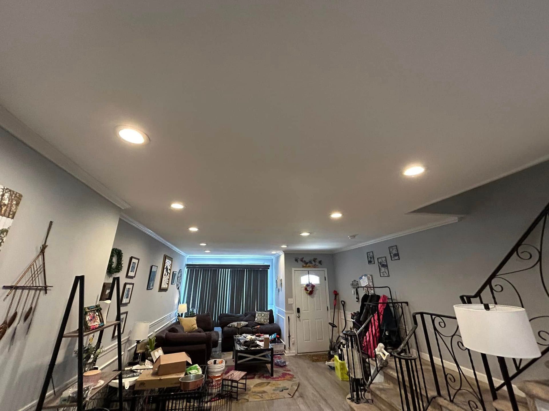 A living room with a couch and stairs in a house.