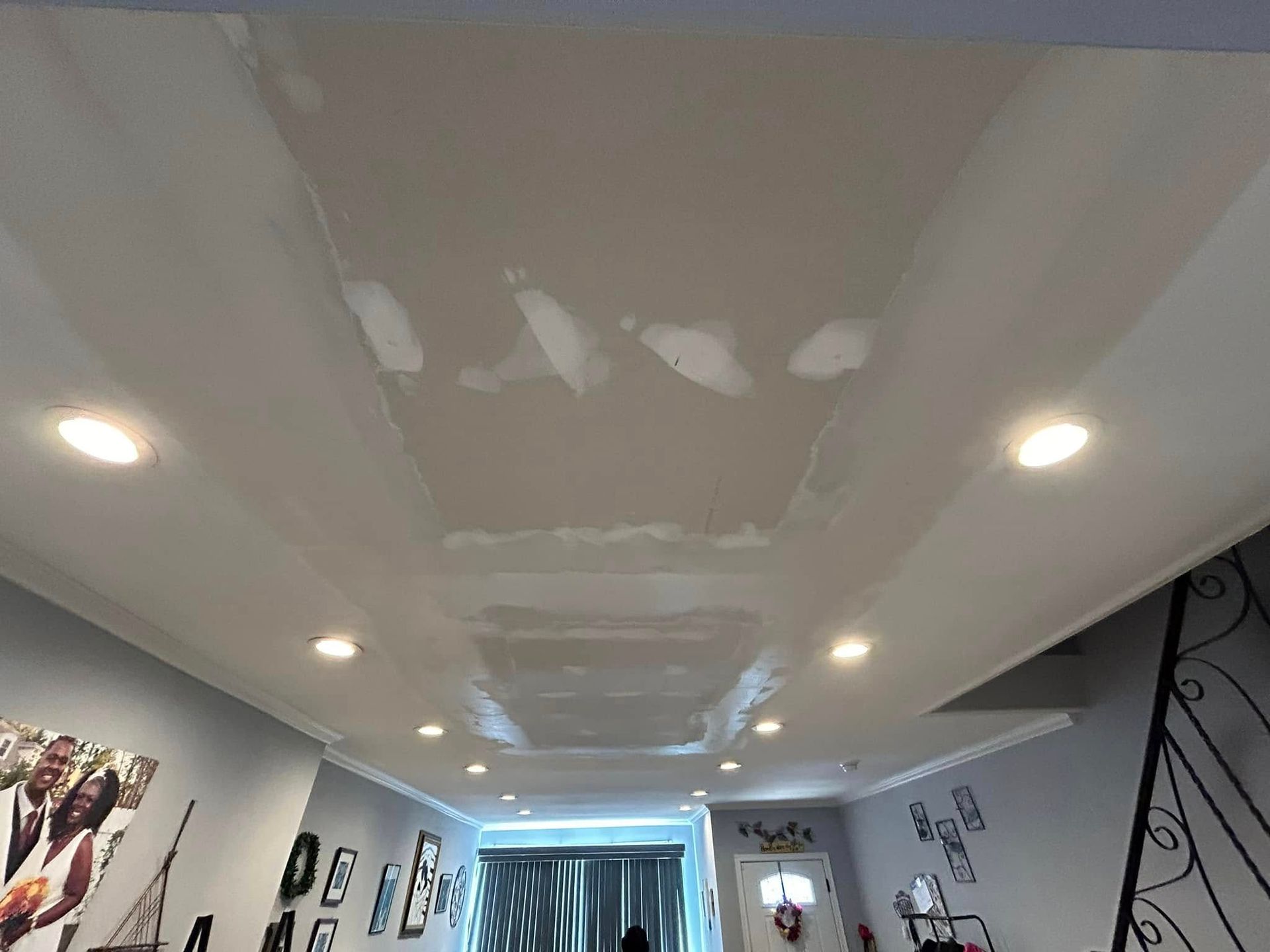 A living room with a white ceiling and a staircase.