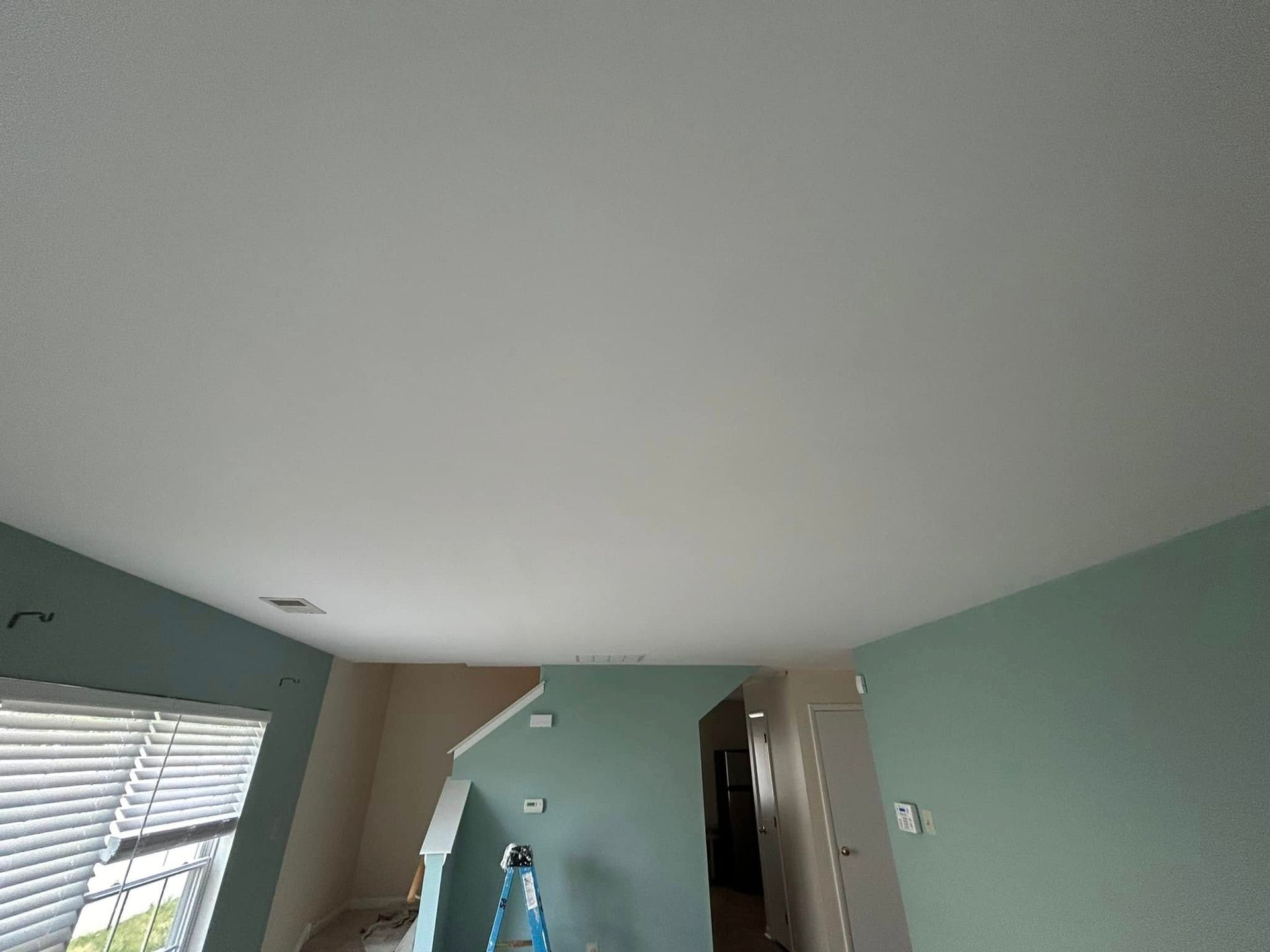A living room with a white ceiling and green walls.