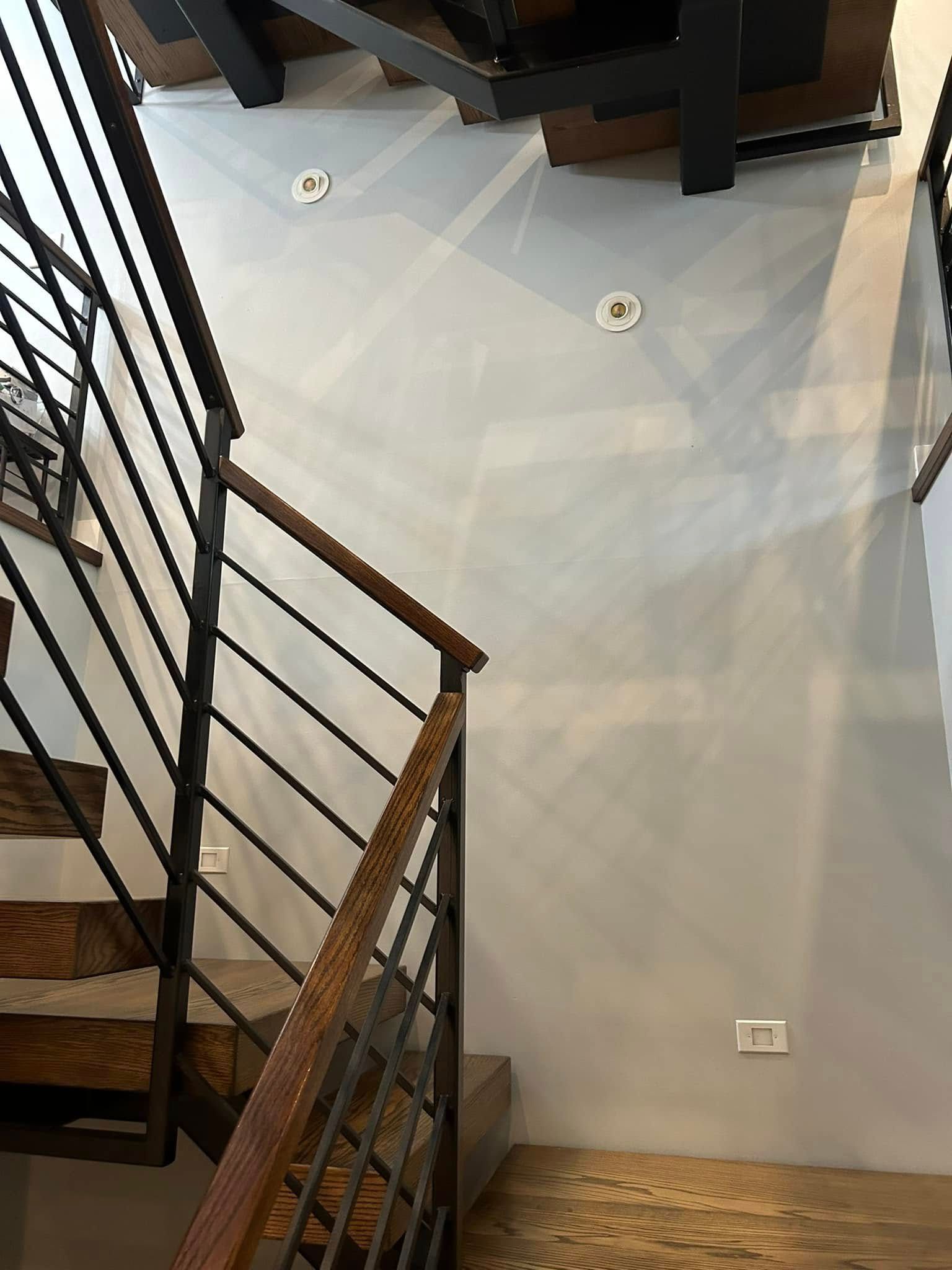 A staircase with a metal railing and wooden steps