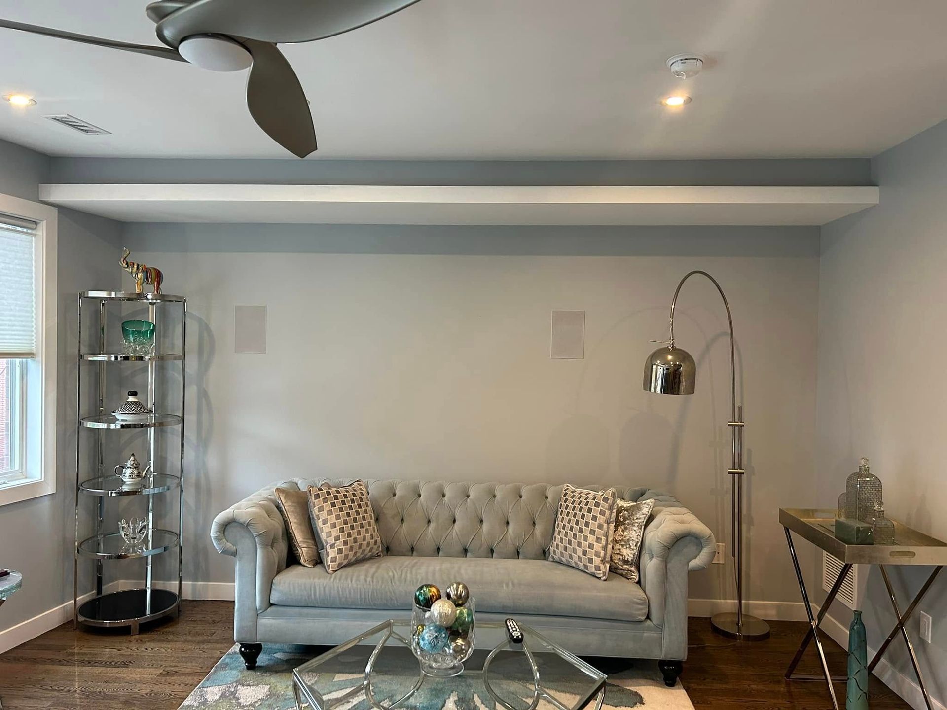A living room with a couch , coffee table , and ceiling fan.
