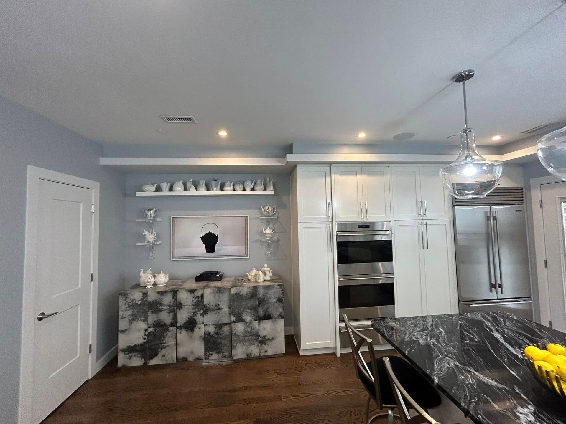 A kitchen with white cabinets and stainless steel appliances