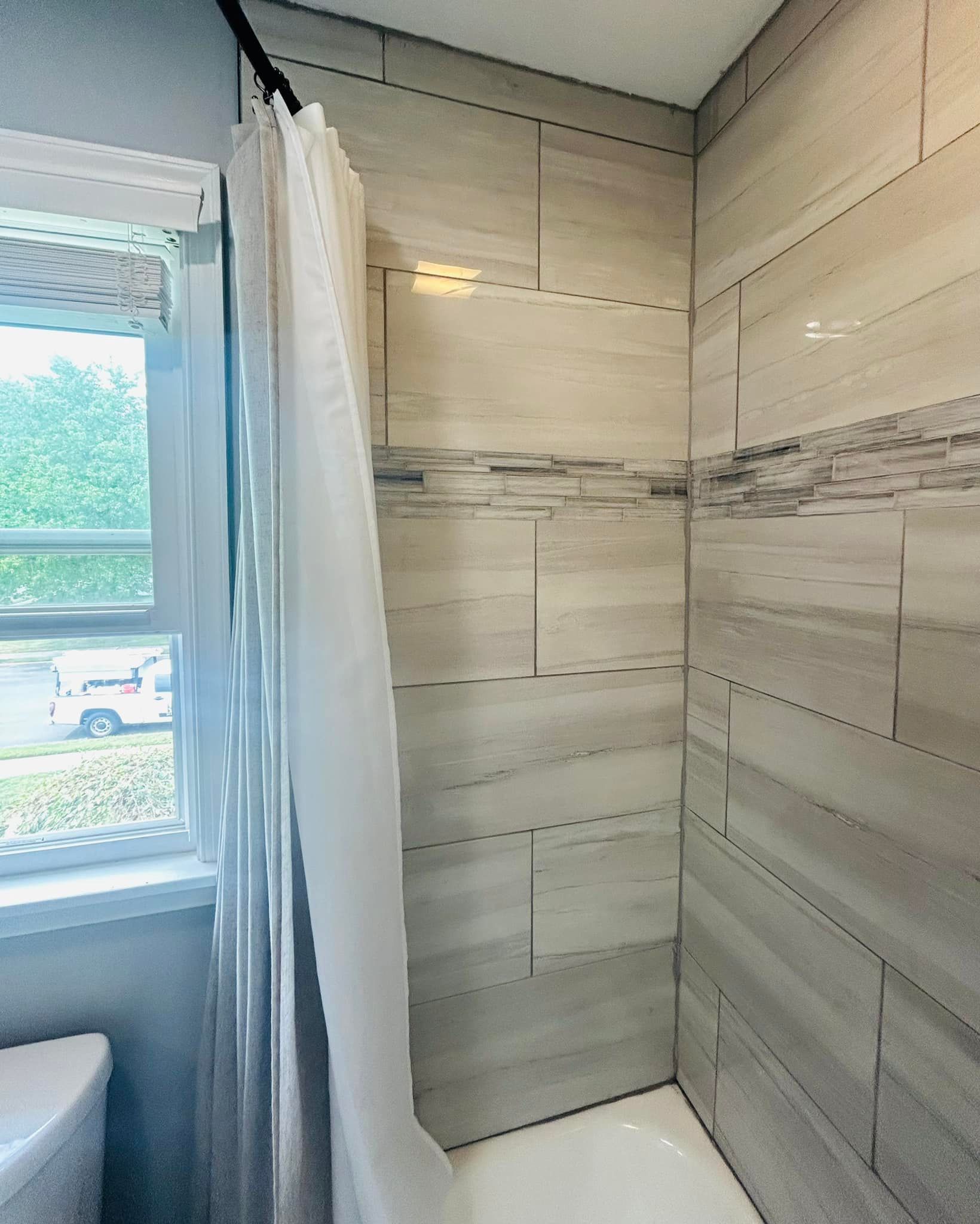 A bathroom with a shower curtain and a toilet.