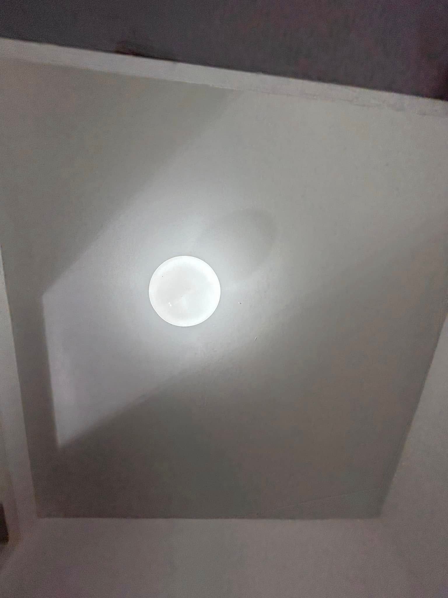 A white ceiling with a light in the middle of it.