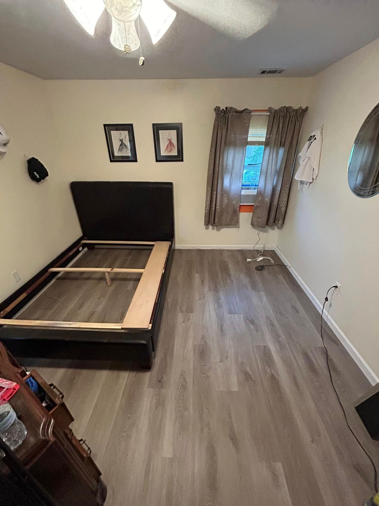 A bedroom with a bed and a ceiling fan.