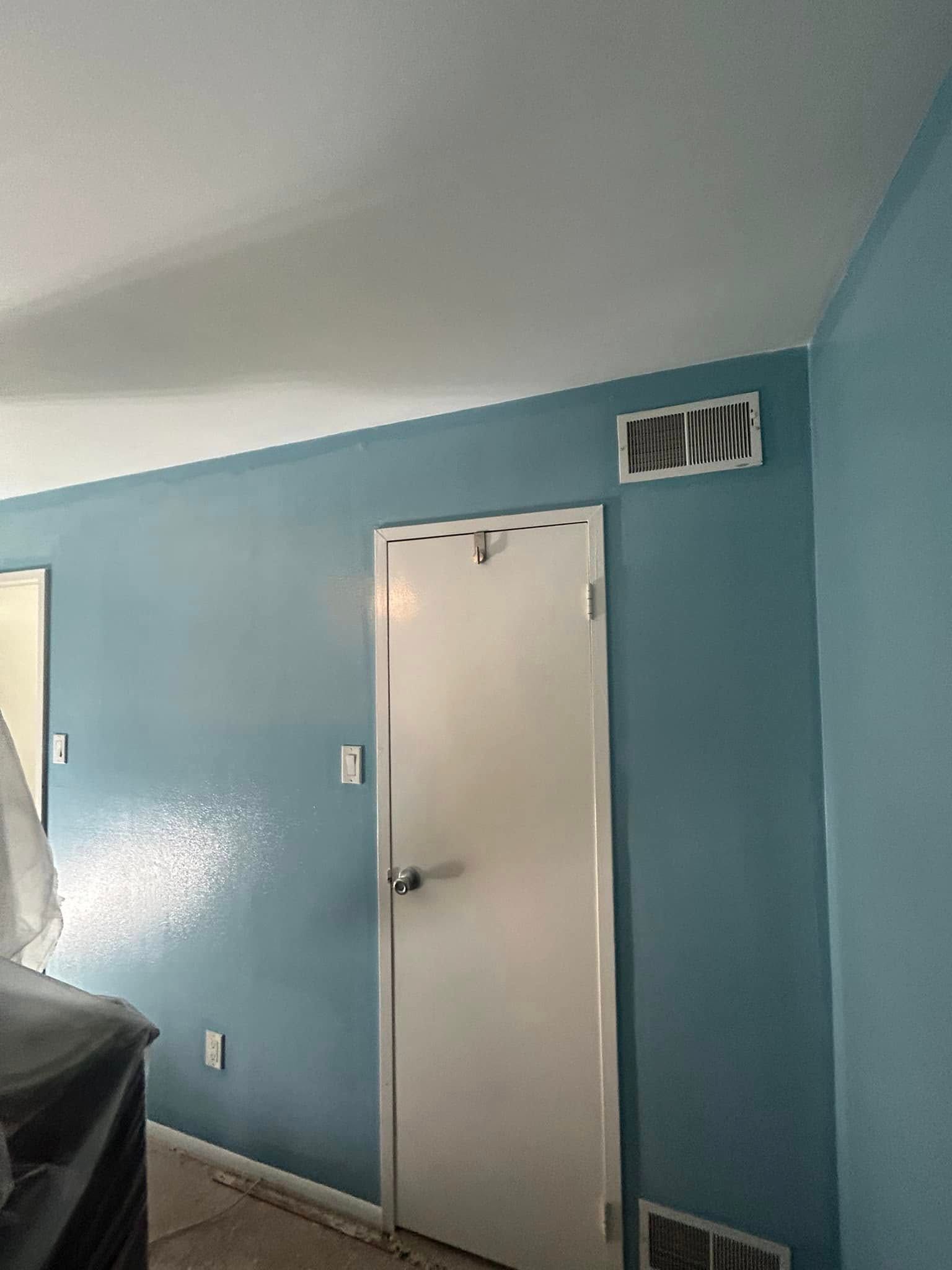 A room with blue walls and a white door.