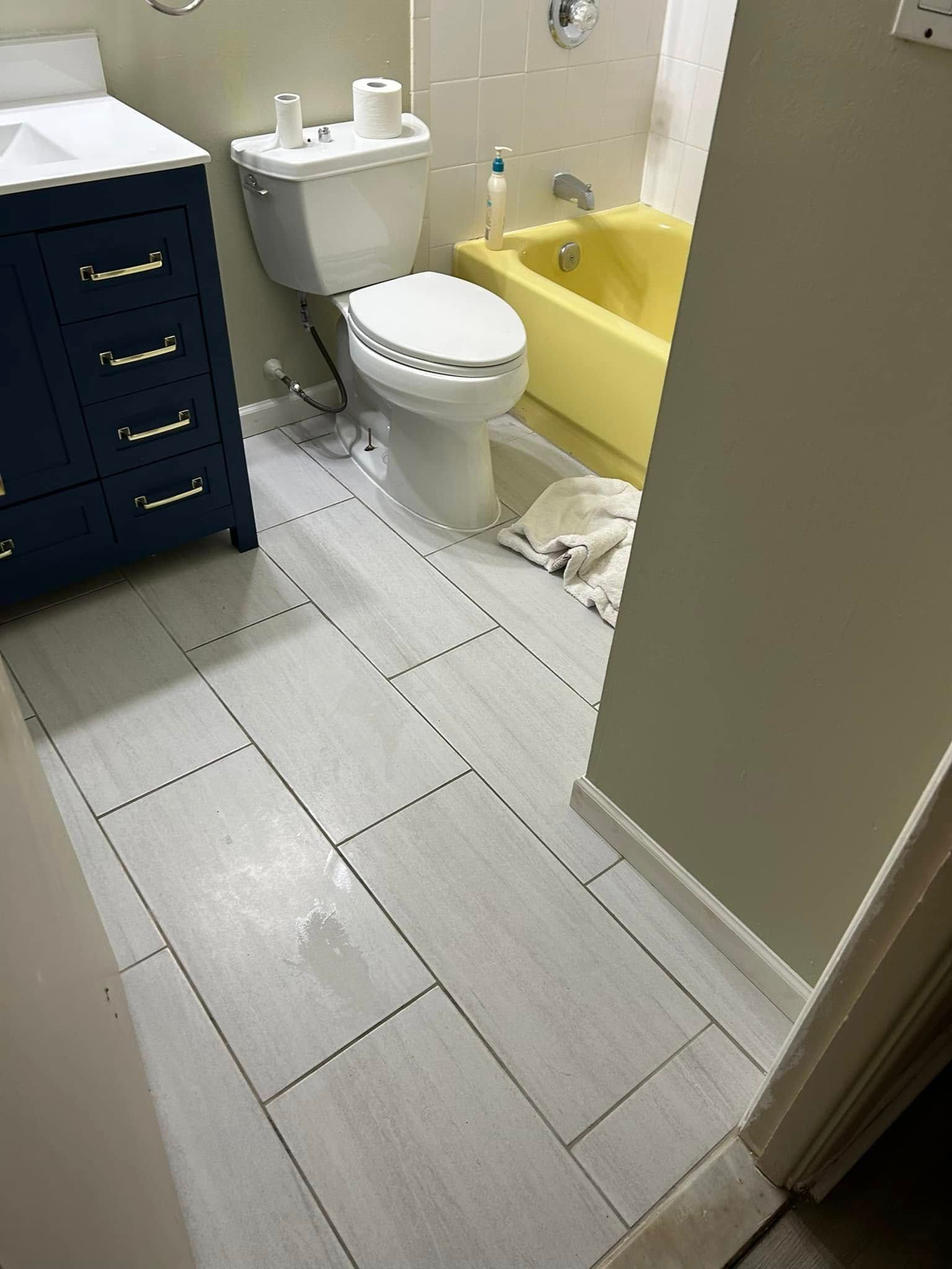 A bathroom with a toilet , sink , and bathtub.