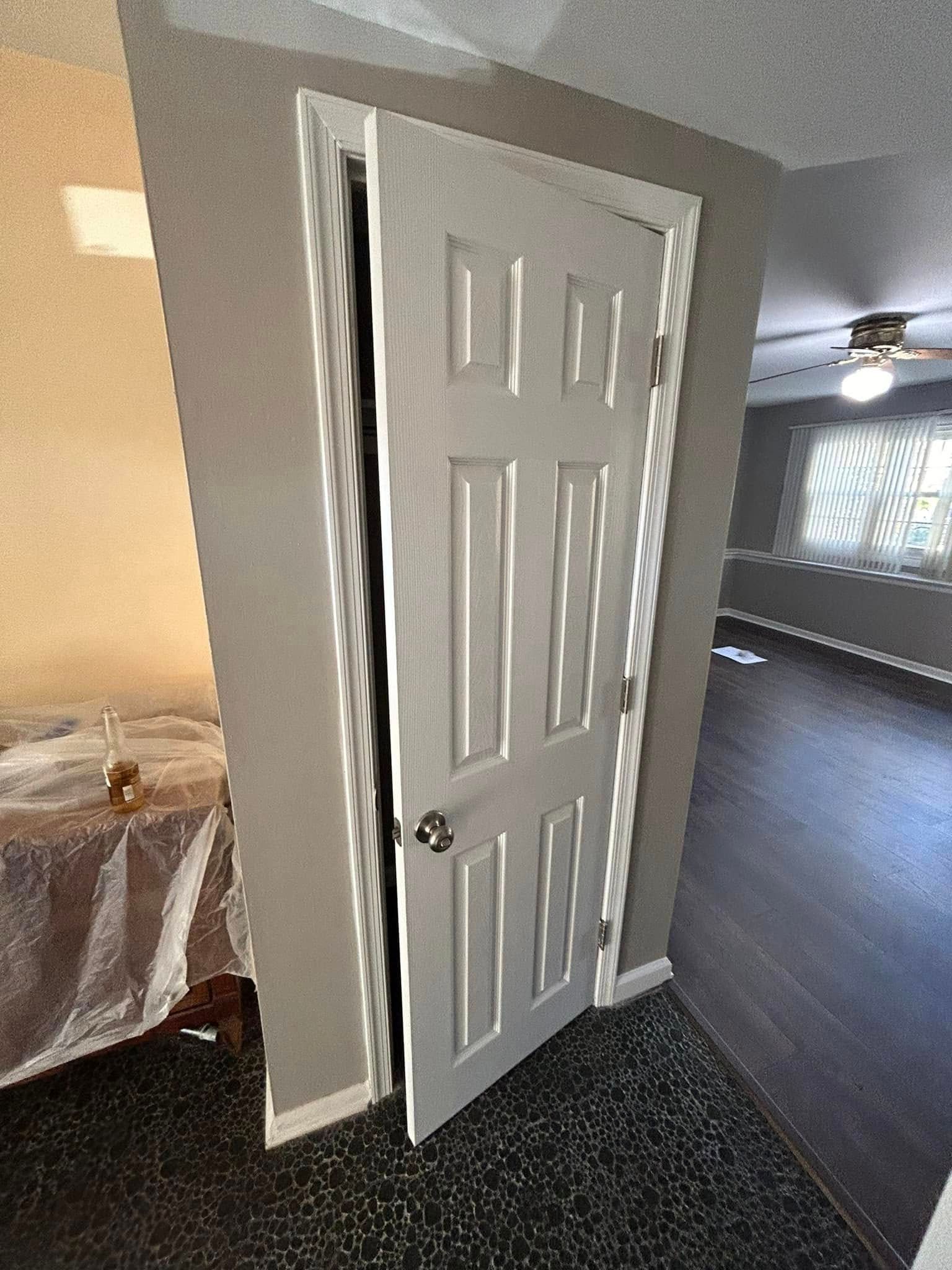 A white door is open in a hallway in a house.