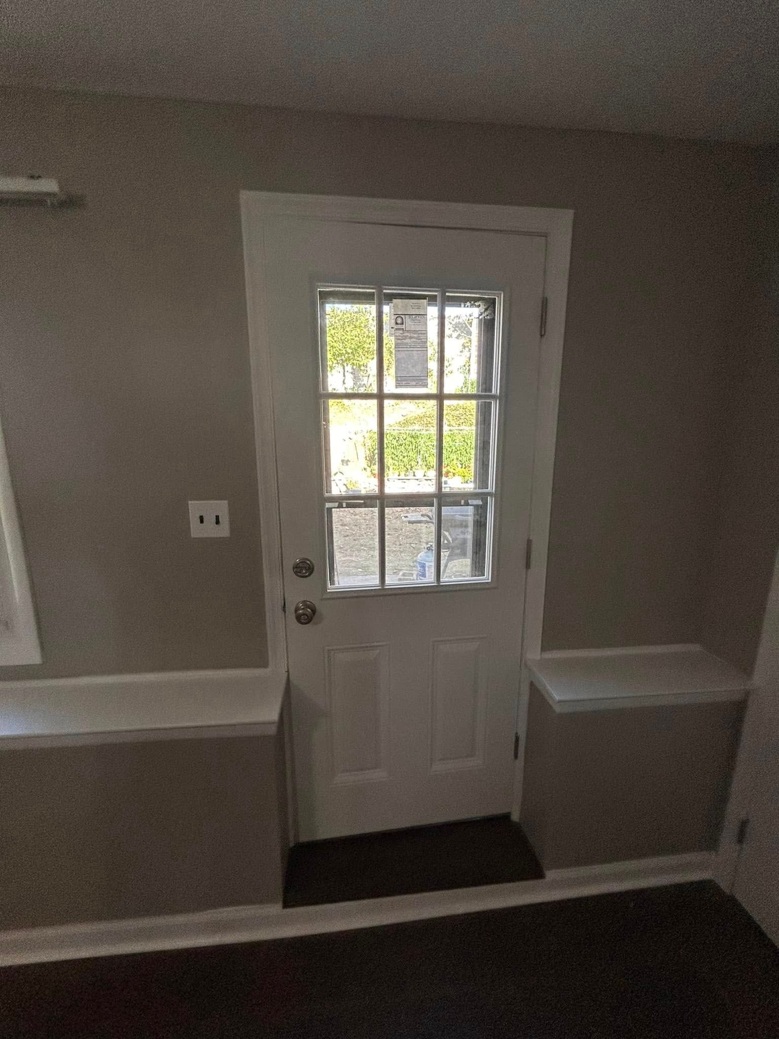 A white door with a window in a room.