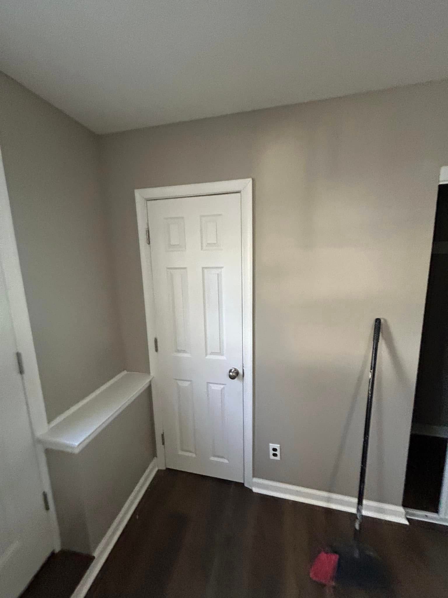 A room with a door and a broom in it
