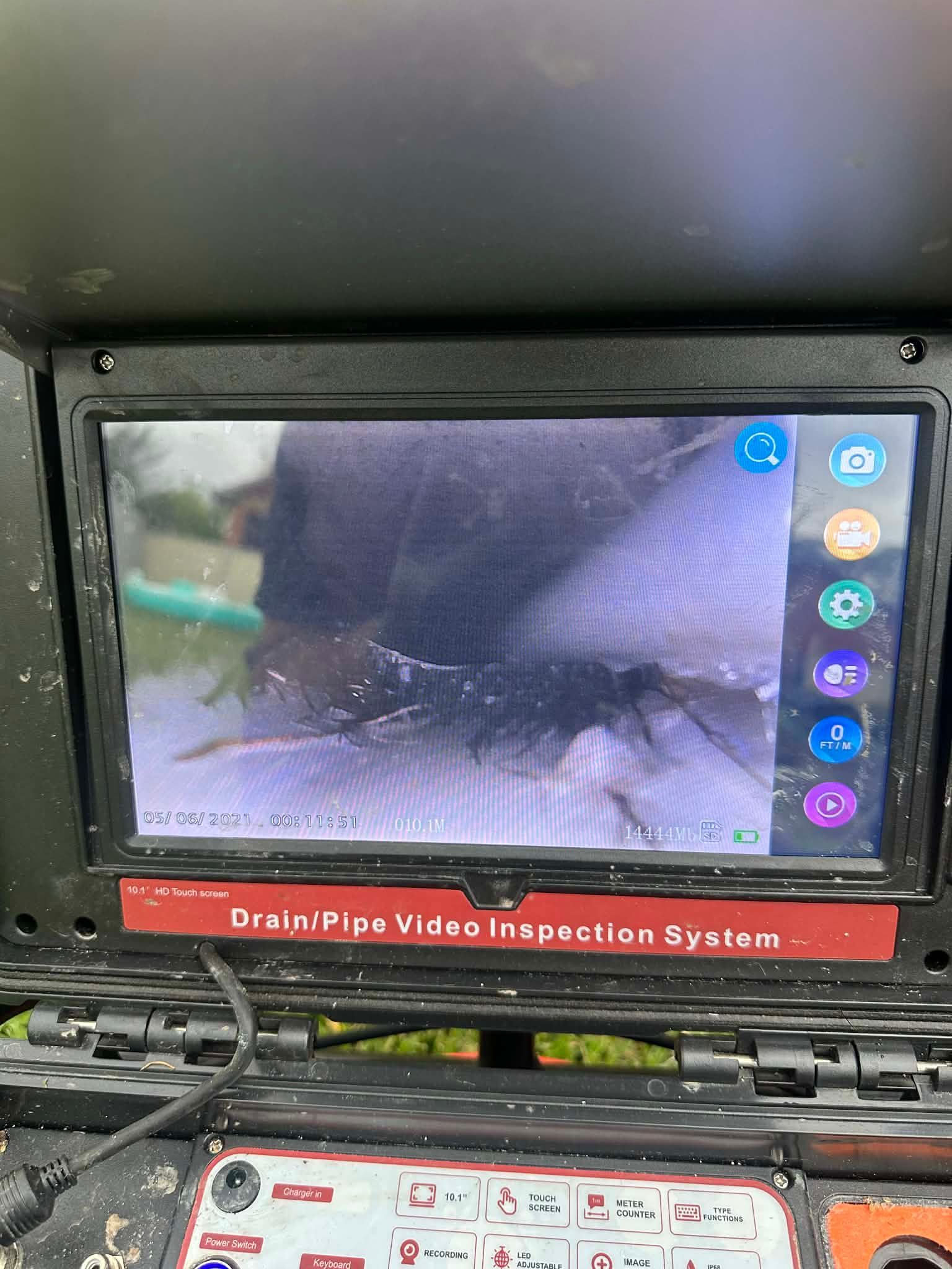 DrainPipe Video Inspection System monitor showing a close-up pipe interior view.