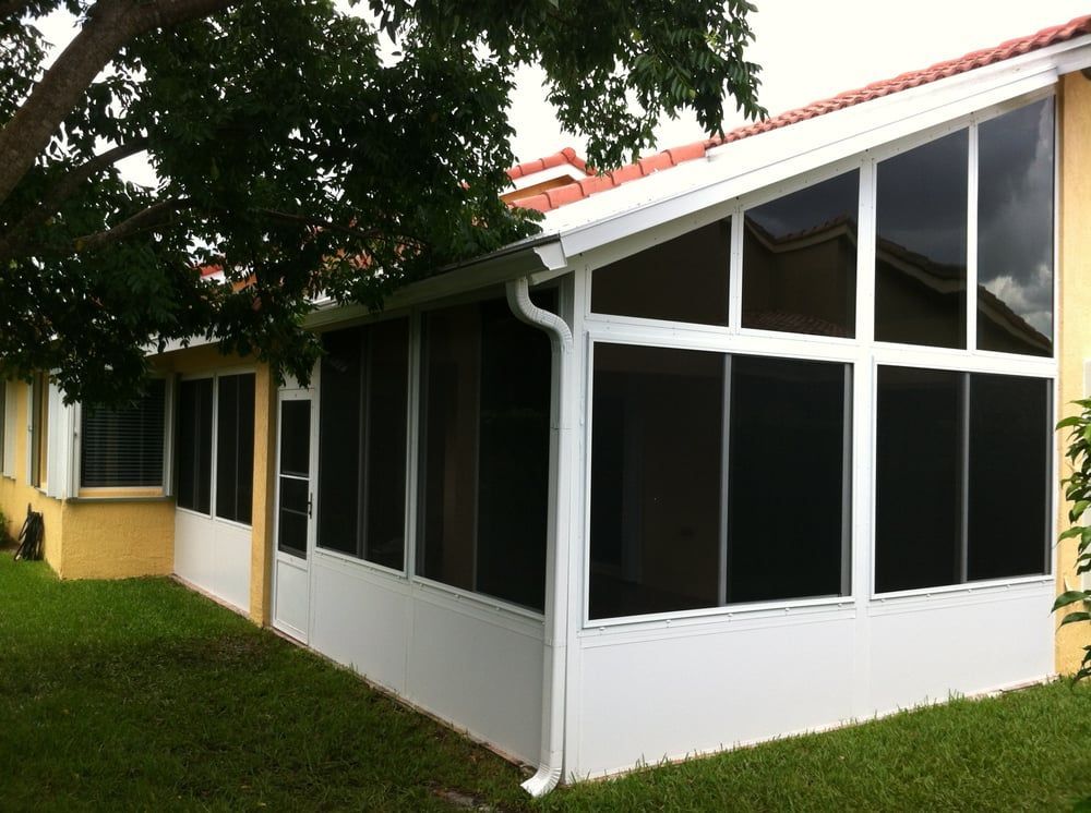 A screened in porch on the side of a house