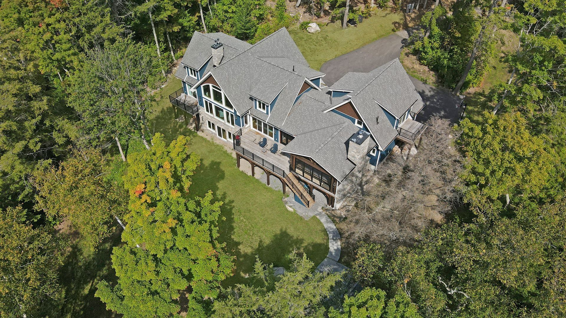 A large house with a large deck and lots of windows