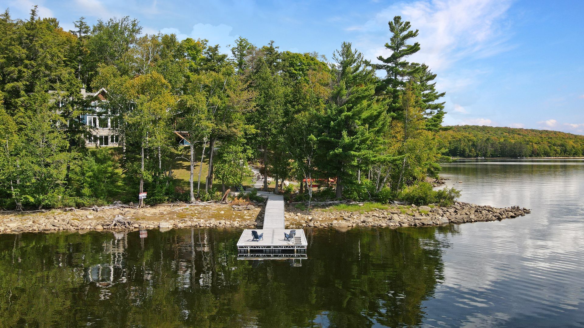 A large house with a large deck and stairs leading up to it.