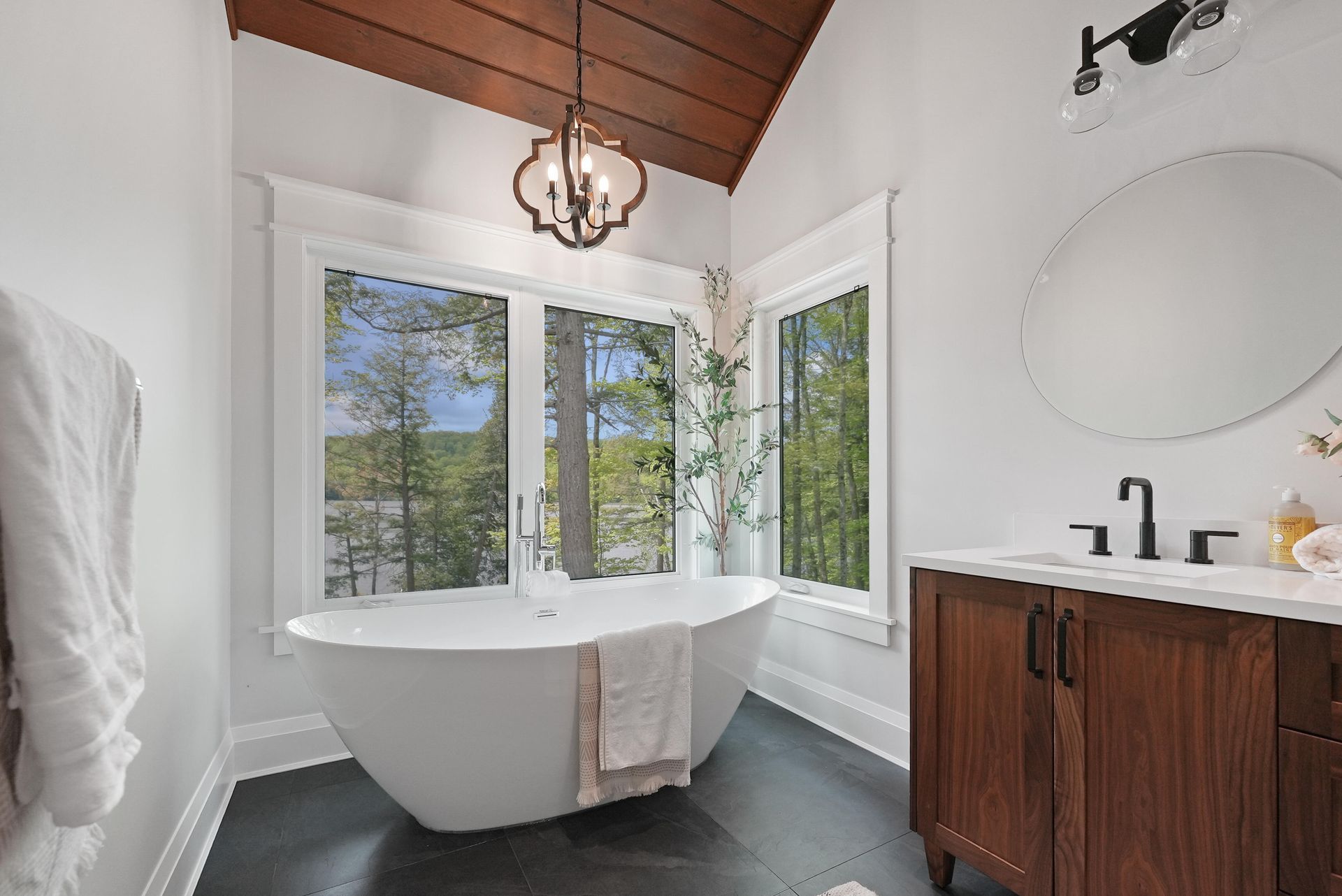 A bathroom with a toilet , sink , mirror and walk in shower.