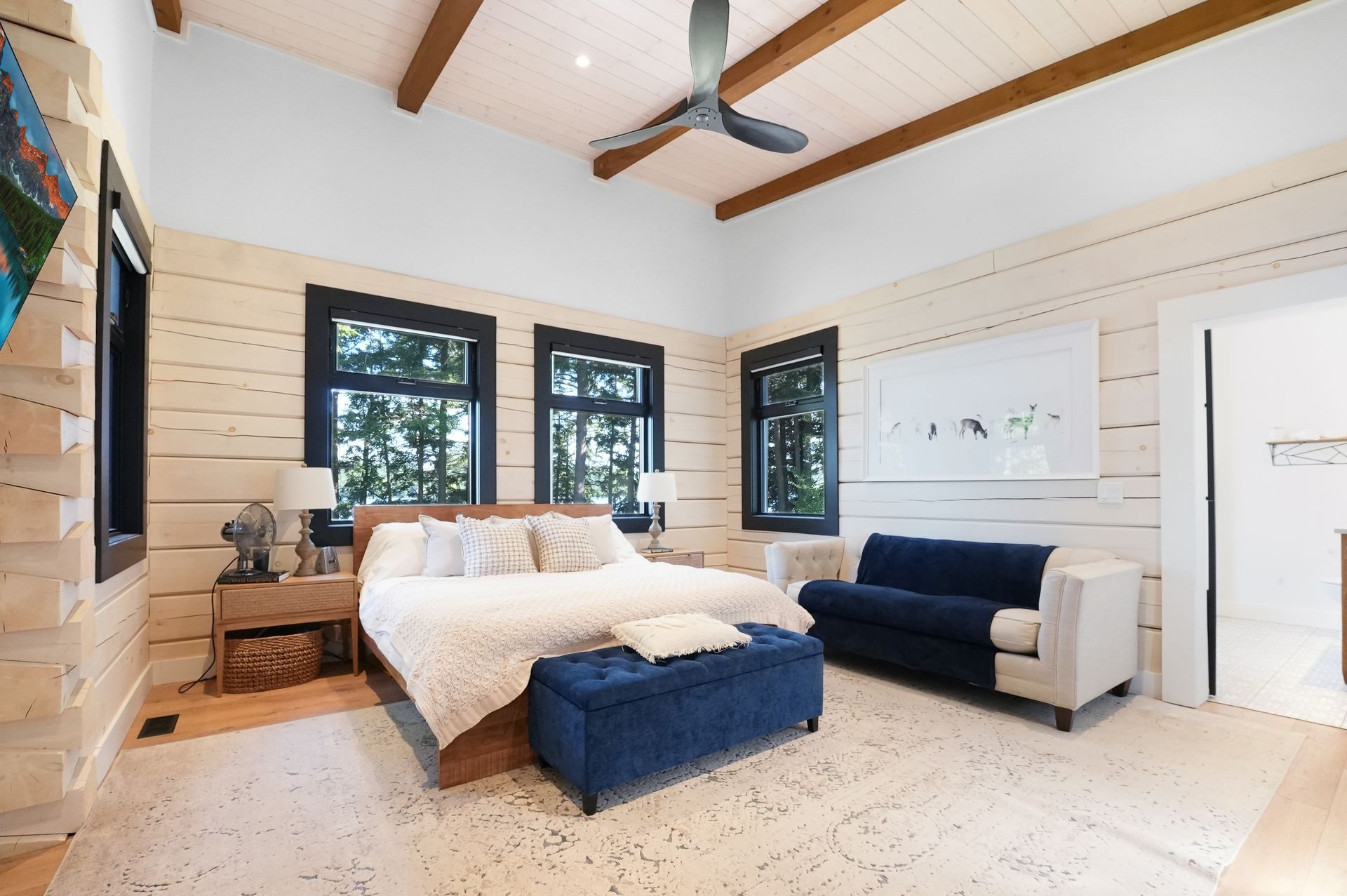 A bedroom with two bunk beds and lots of windows.
