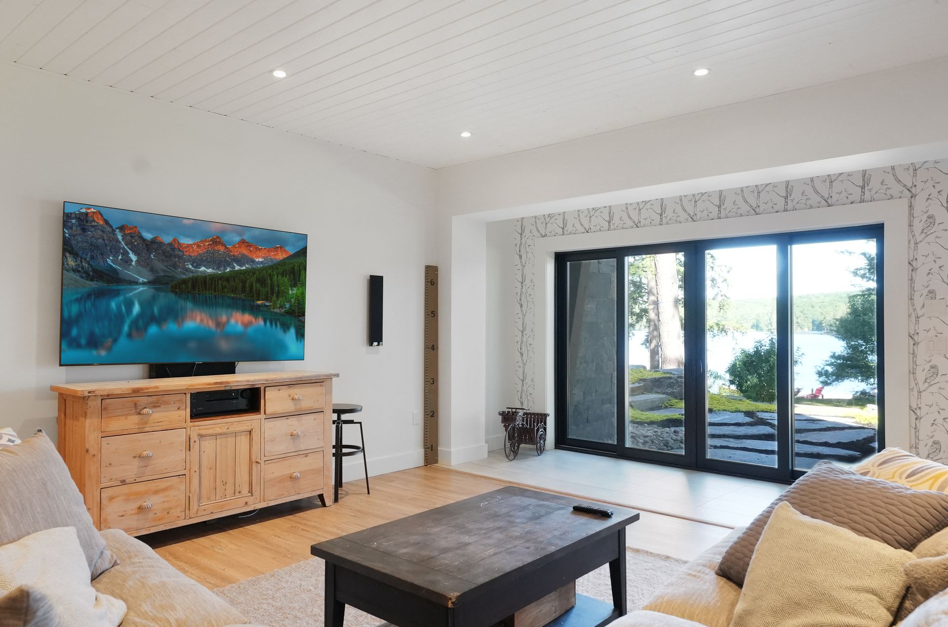 A wooden sauna with a glass door and towels on the floor.