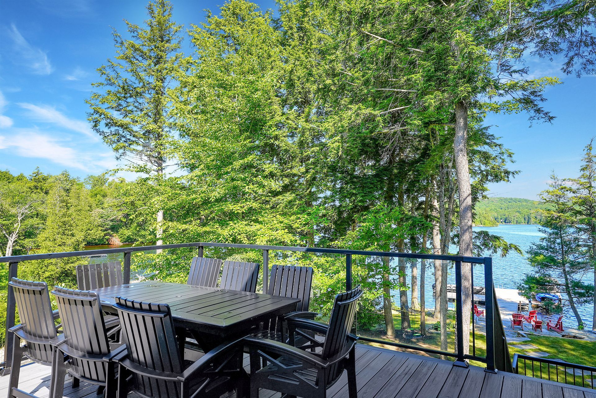 A large deck with a table and chairs and umbrellas.