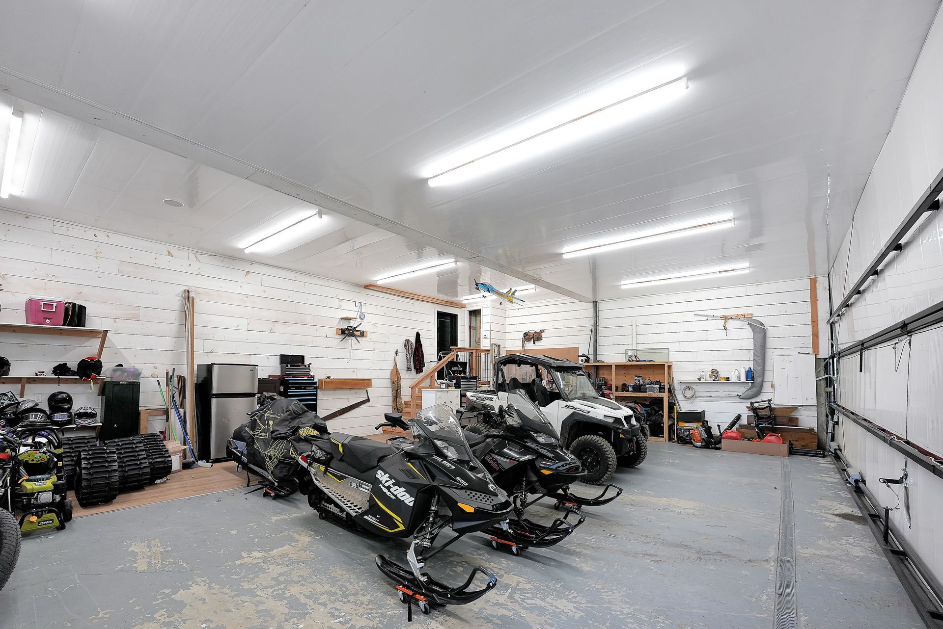 A wooden garage is sitting next to a lake in the woods.