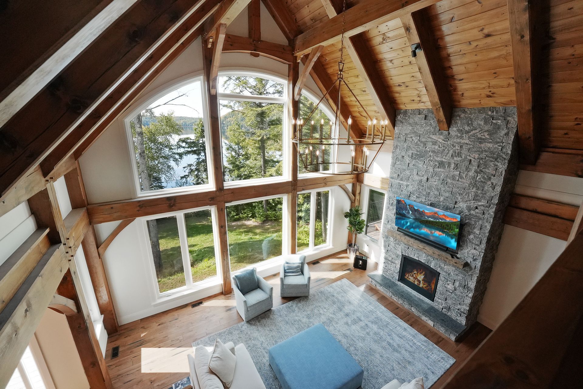 A living room with a couch , chair , television and fireplace.