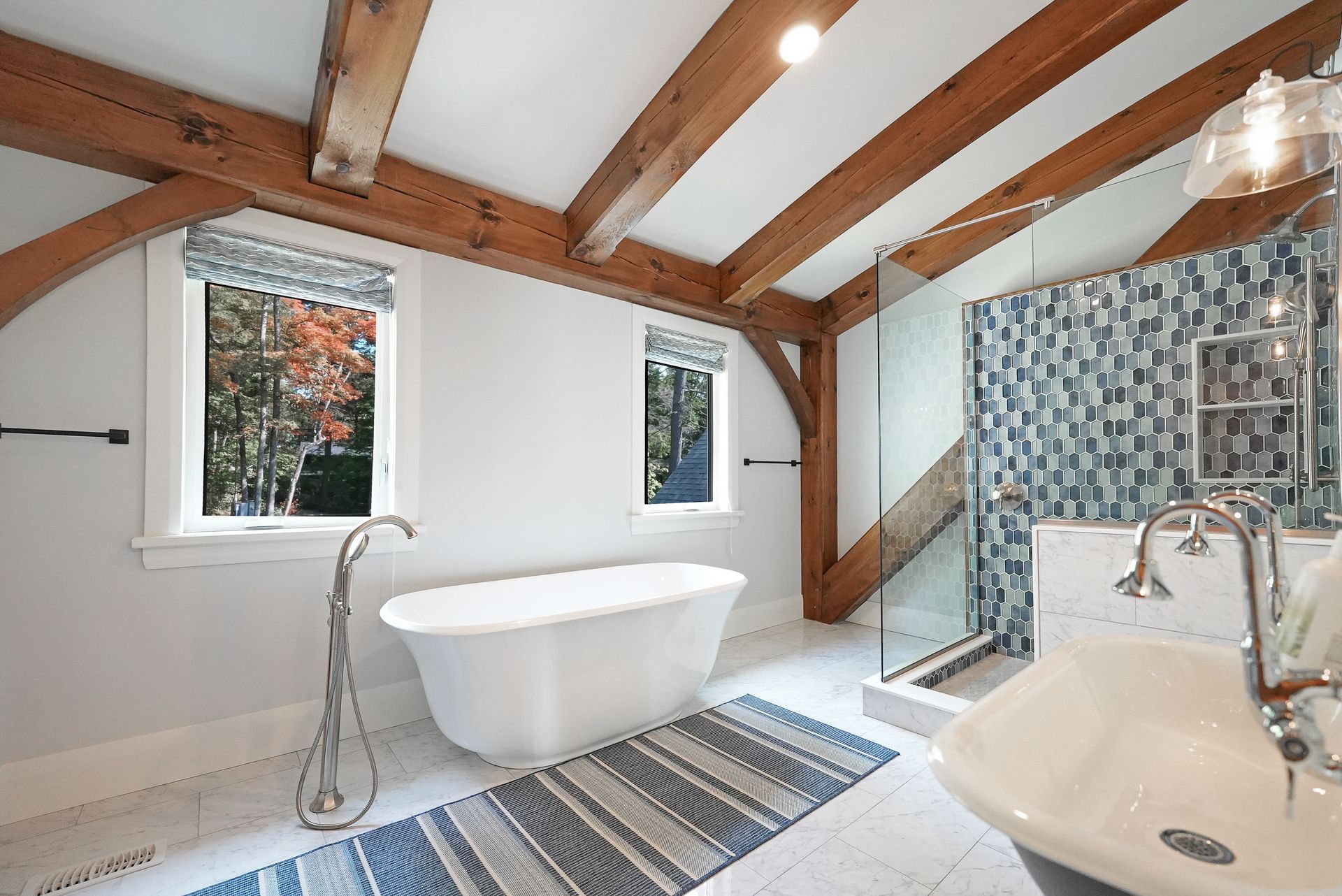 A game room with a bar , stools , a pool table and a flat screen tv.