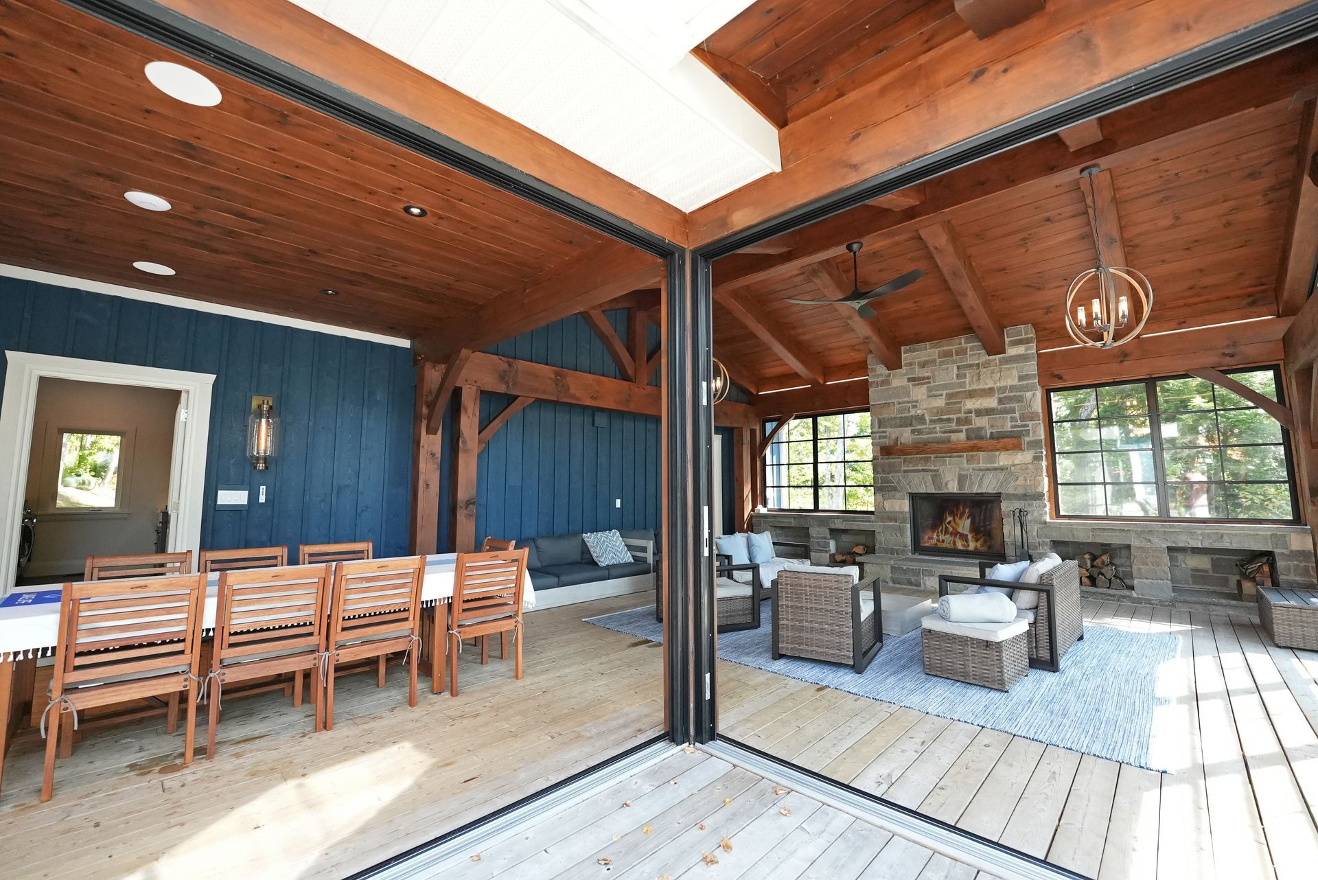 Two red adirondack chairs are sitting on a dock overlooking a lake.