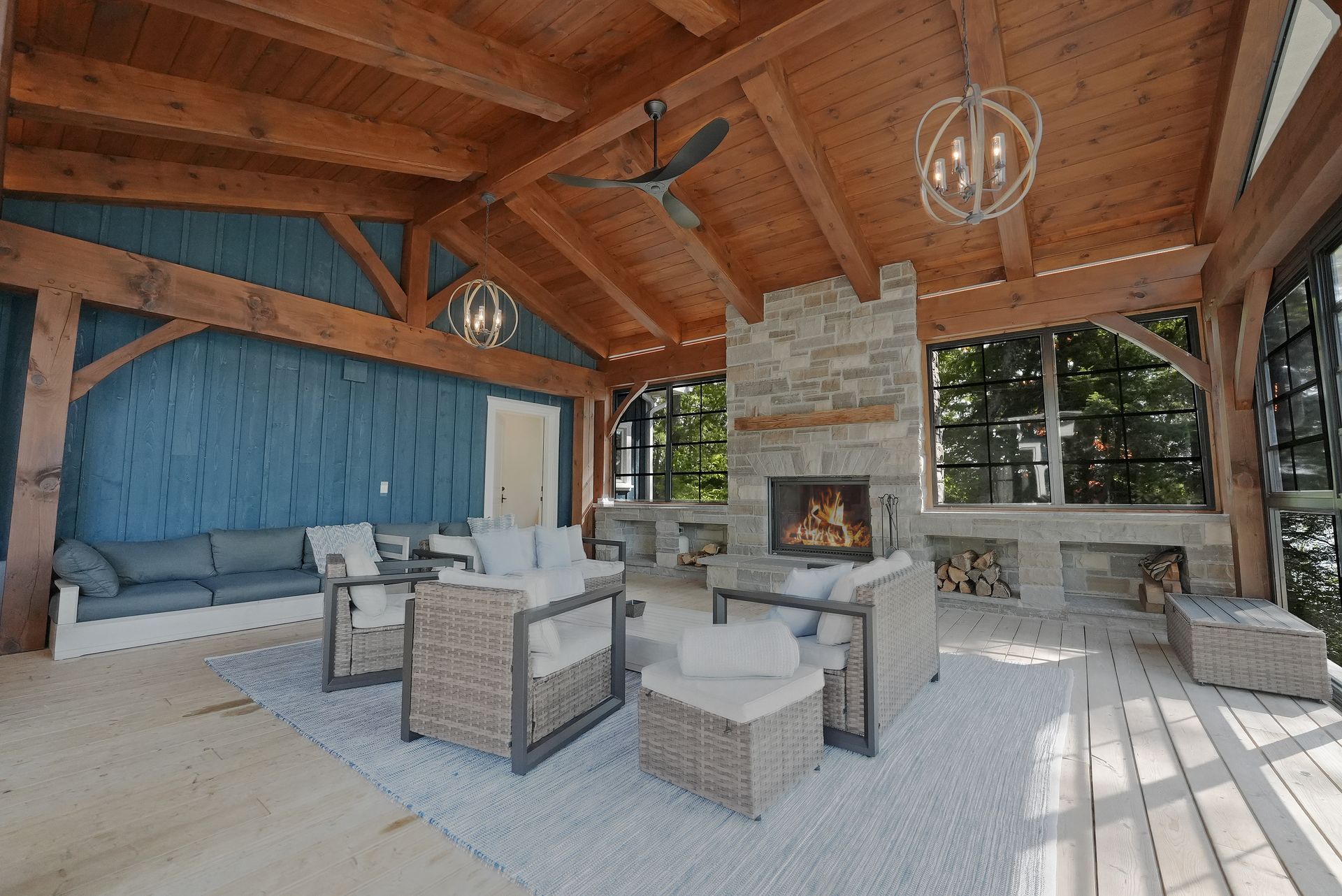 A living room with a lot of windows and a ceiling fan.