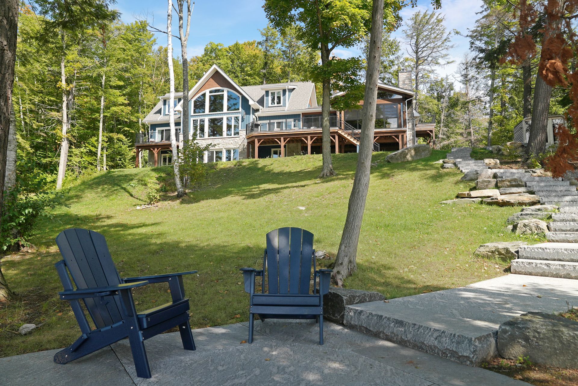 Two chairs are sitting on a deck in front of a building.