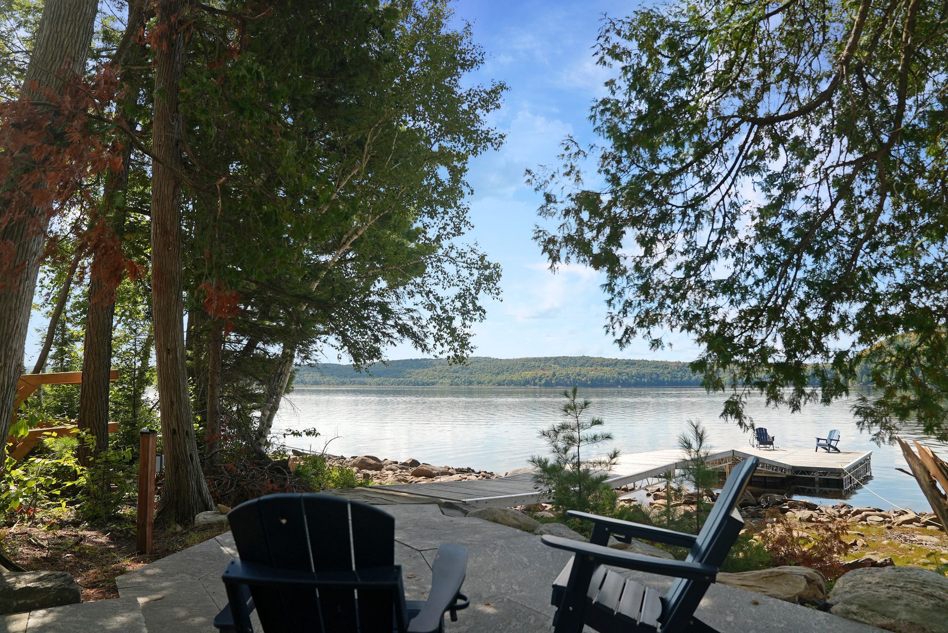 A large deck with a table and chairs and umbrellas.