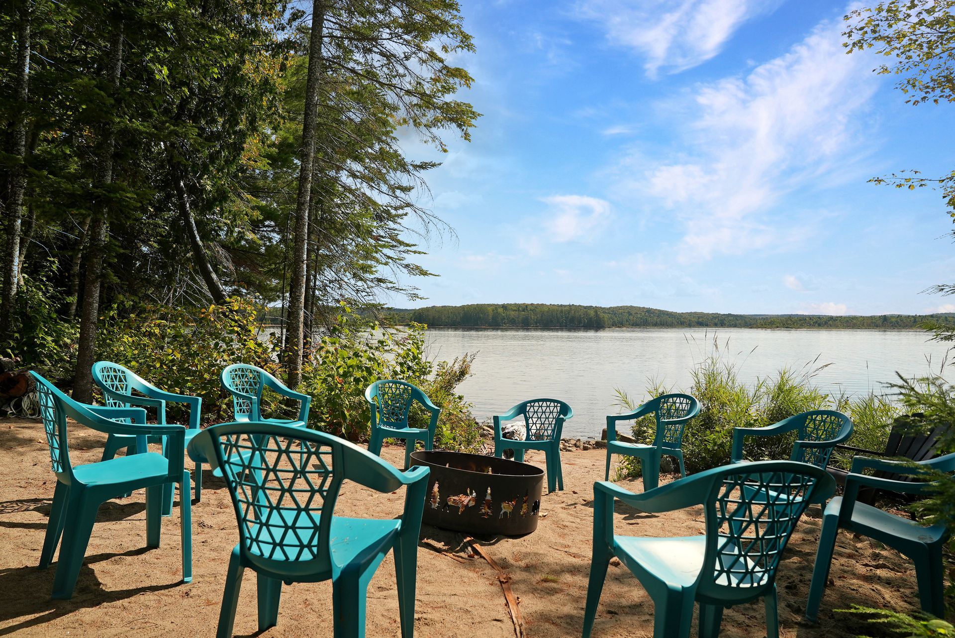 There are two chairs on the porch of a house.