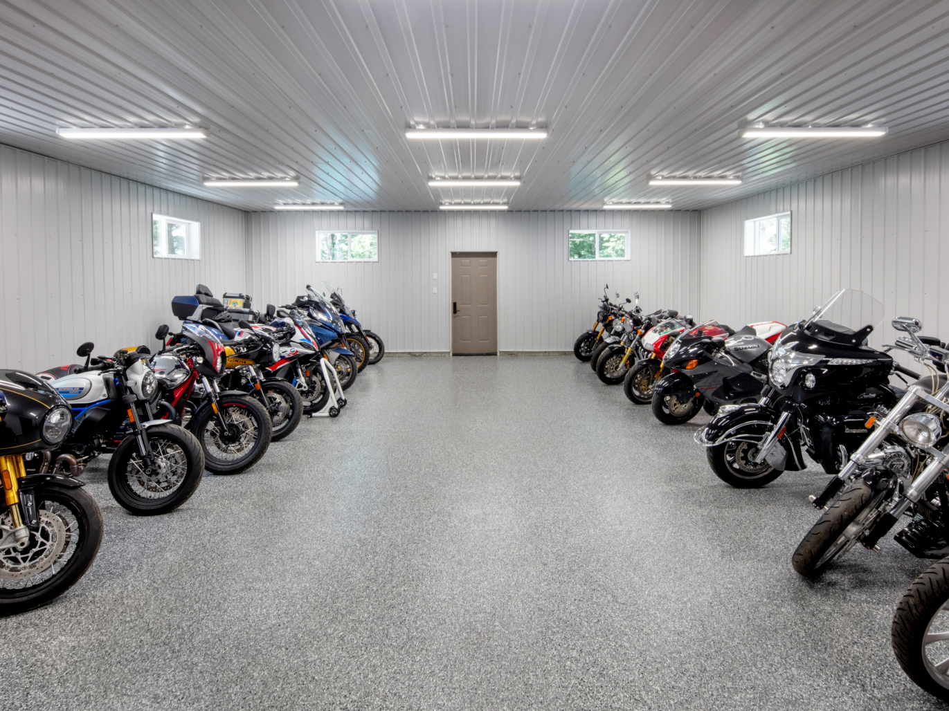 A garage filled with lots of motorcycles parked in a row.