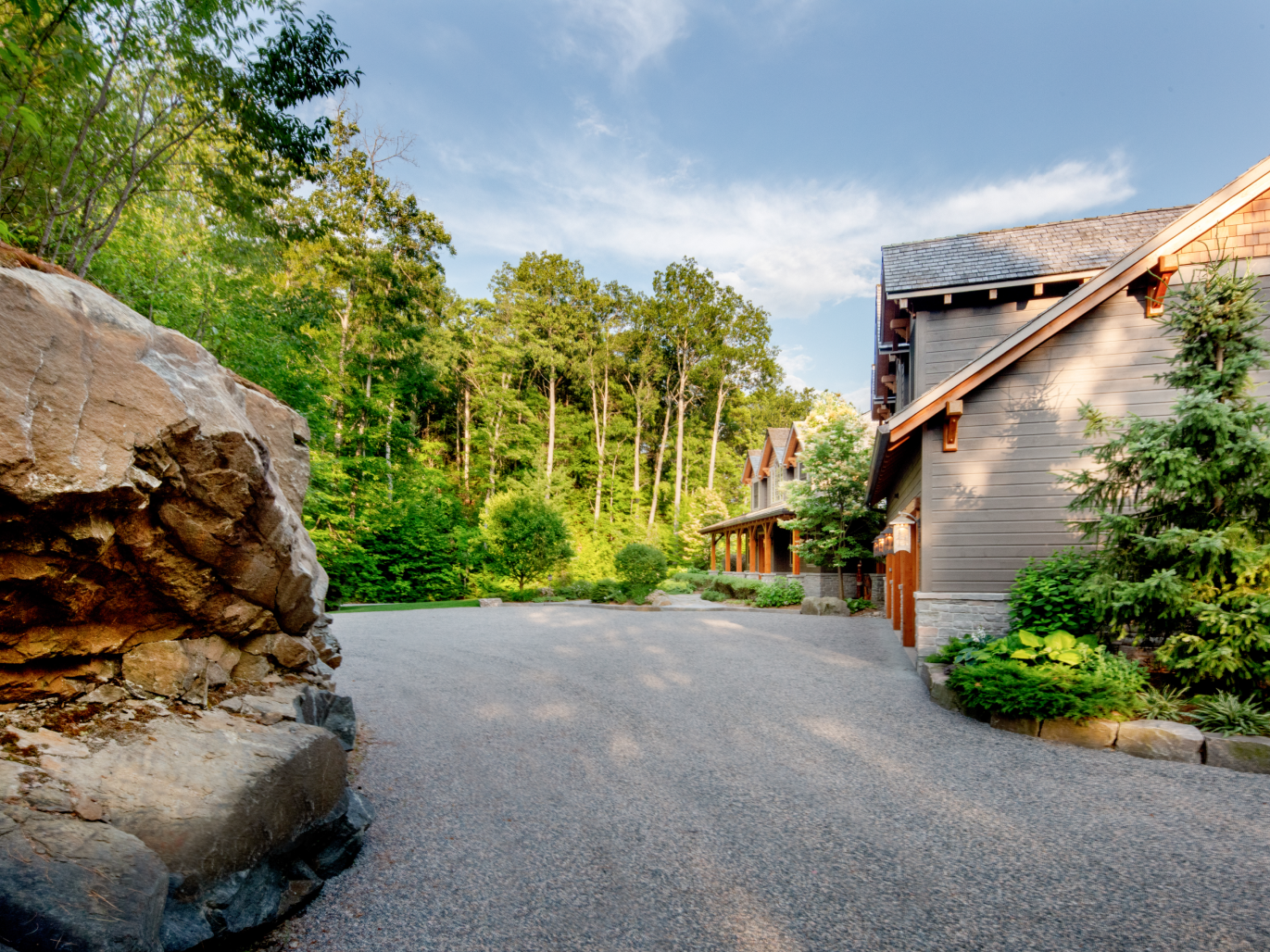 A driveway leading to a house with trees in the background