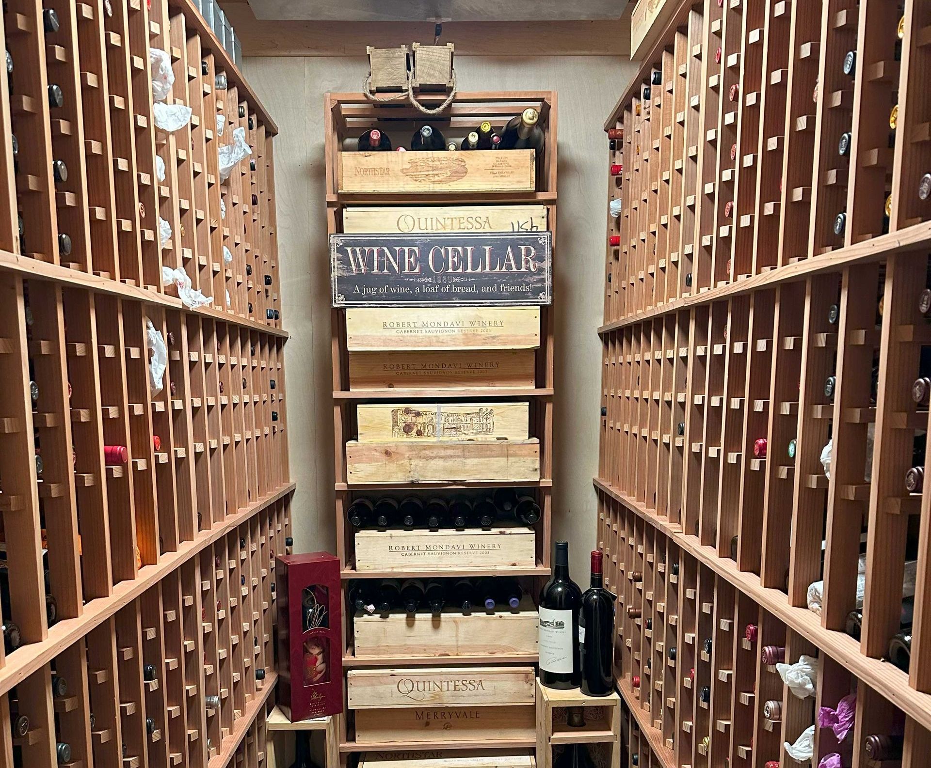 A wine cellar filled with lots of wine bottles and crates.