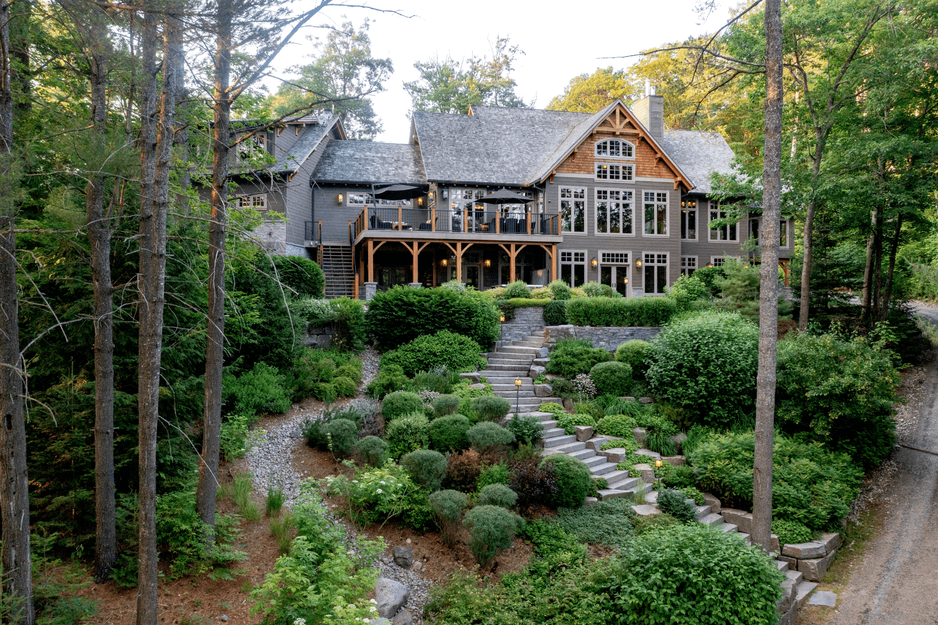 A large house is surrounded by trees and bushes
