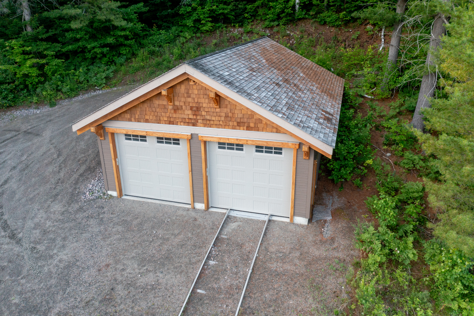 An aerial view of a garage in the middle of a forest.