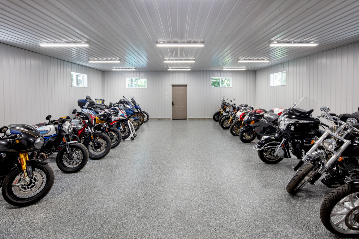 A row of motorcycles are parked in a garage.