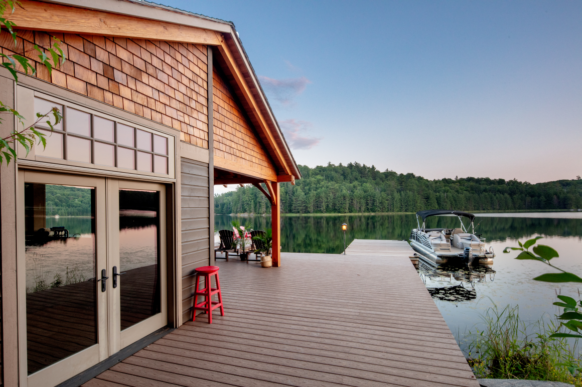 A boat is docked at a dock next to a house.