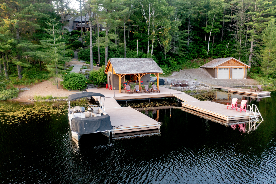 A boat is docked at a dock next to a house on a lake.