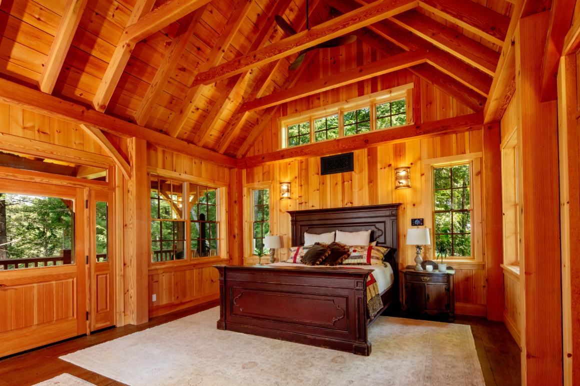 A bedroom with a king size bed and lots of windows